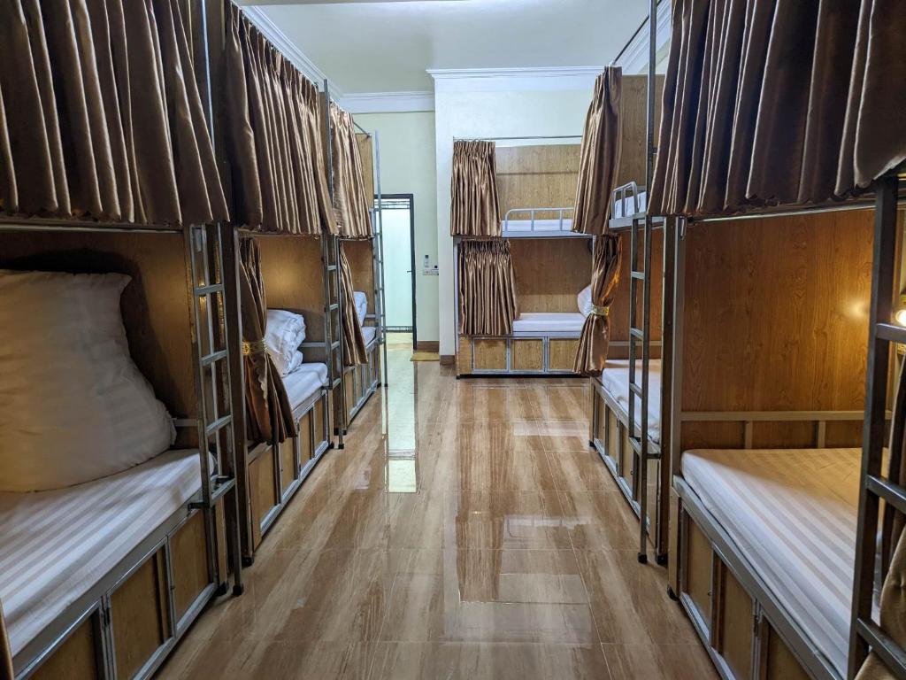 a room filled with bunk beds with wooden floors at Train Station Backpackers Hostel in Ninh Binh