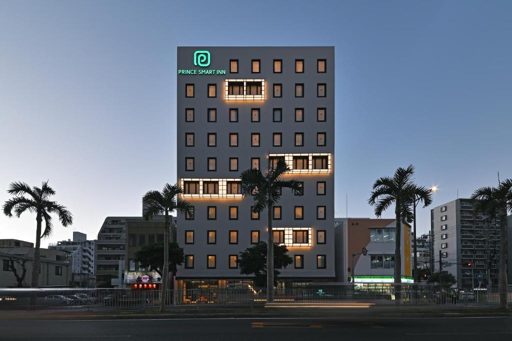 a tall building with palm trees in a city at Prince Smart Inn Naha in Naha