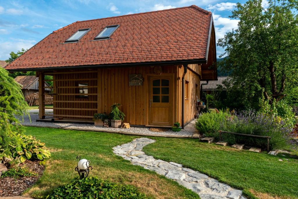 uma casa com um telhado vermelho e uma ovelha no quintal em Glamping Happiness with Sauna and Natural Pool em Ribnica