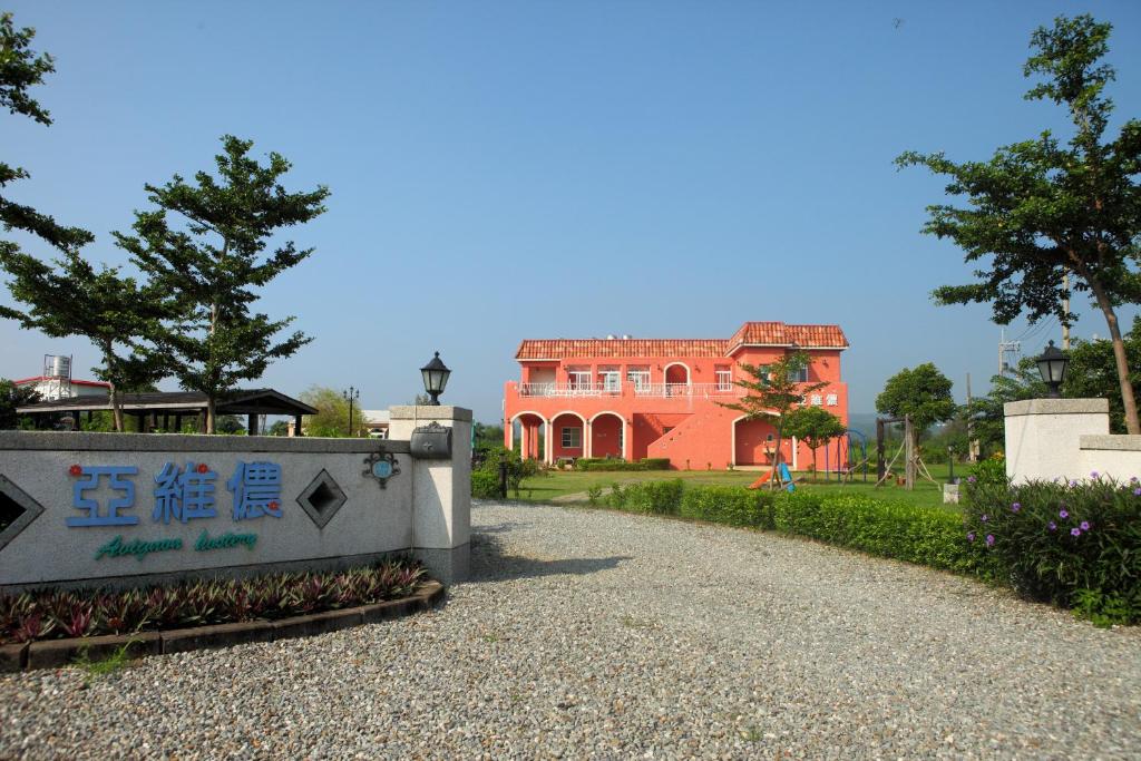 a large red house with a sign in front of it at Kenting Avignon in Hengchun South Gate