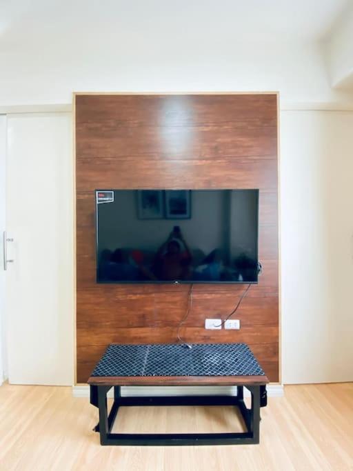 a bench in front of a flat screen tv at Functional 1-br Space in Amaia with Fast Internet in Mandaue City
