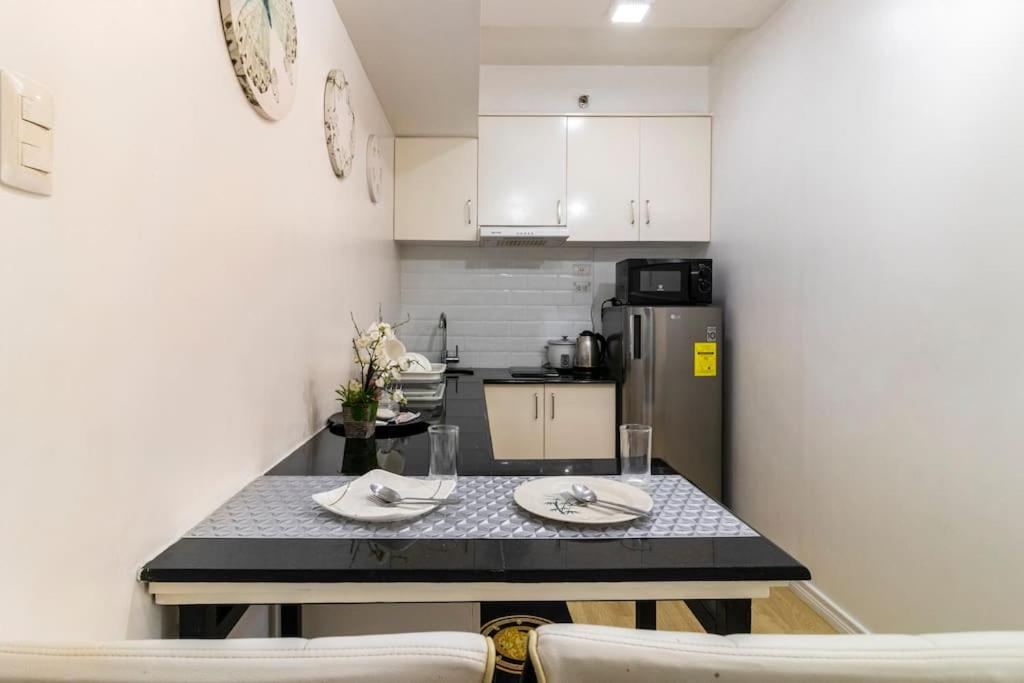 a kitchen with a table and two chairs and a refrigerator at Functional 1-br Space in Amaia with Fast Internet in Mandaue City