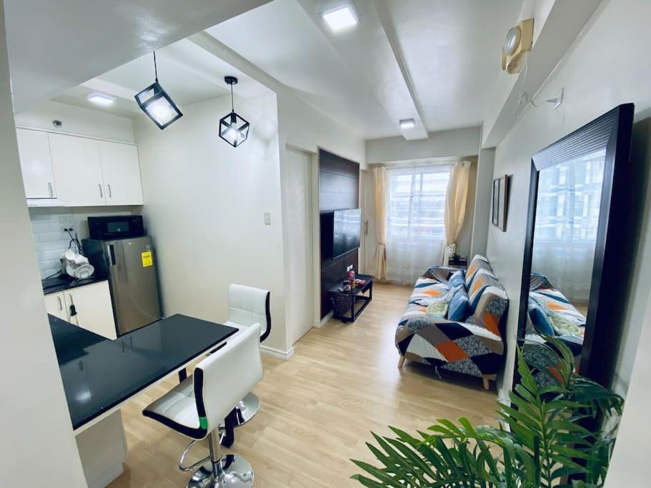 a kitchen and living room with a desk and a couch at Functional 1-br Space in Amaia with Fast Internet in Mandaue City
