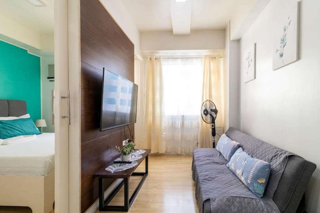 a living room with a couch and a bed at Functional 1-br Space in Amaia with Fast Internet in Mandaue City