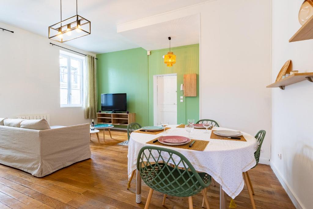 a living room with a table and chairs and a couch at Côté Cour - Centre Ville- Calme - Charme - 4 Voyageurs in Dijon