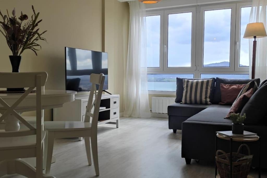 - un salon avec un canapé, une table et une télévision dans l'établissement C01A05 Precioso apartamento con vistas al mar, à Santander