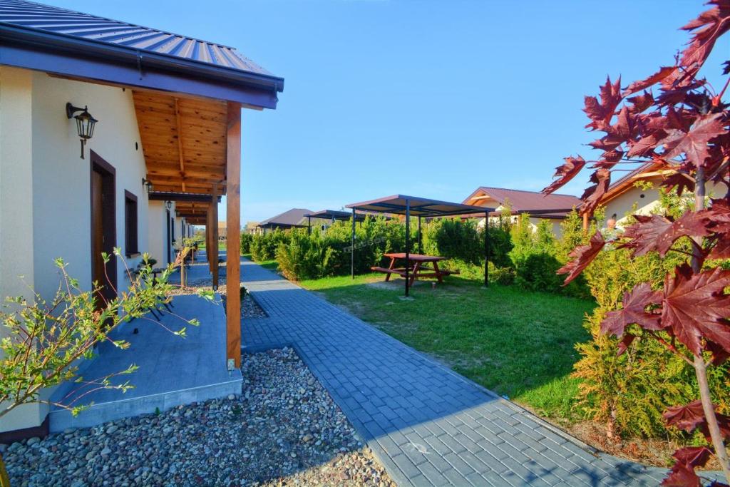 a backyard with a picnic table and an umbrella at Stajnia Bocianie Gniazdo in Uniejow