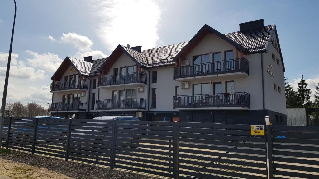 a house with cars parked in front of it at Apartament na Zaciszu in Kąty Rybackie