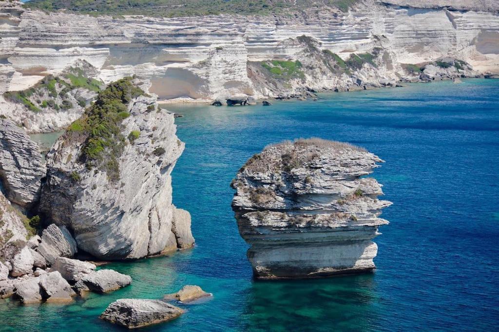 a large rock formation in the middle of a body of water at Casa Agatha : Villa avec piscine in Figari