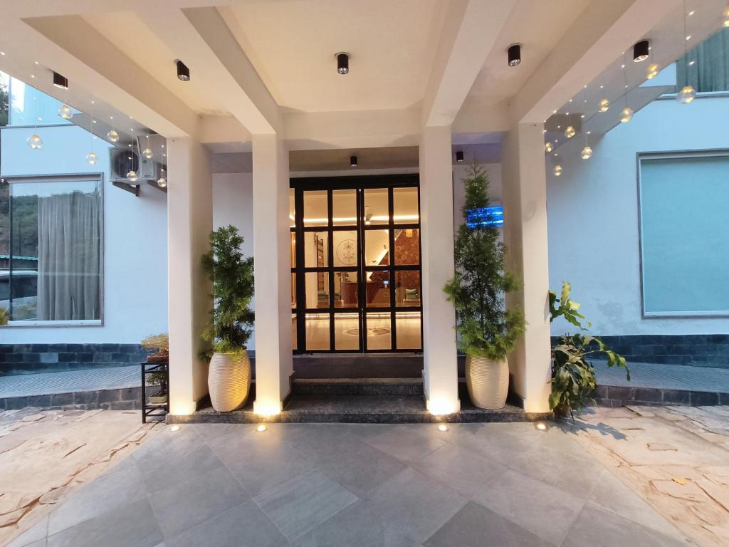 Ataraxia Crestmont Resort & Spa في دهرادون: لوبي فندق فيه باب فيه نباتات الفخار
