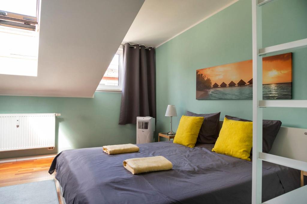 a bedroom with a large bed with yellow pillows at Rosenthaler Calling - Rooftop Apartment in Berlin