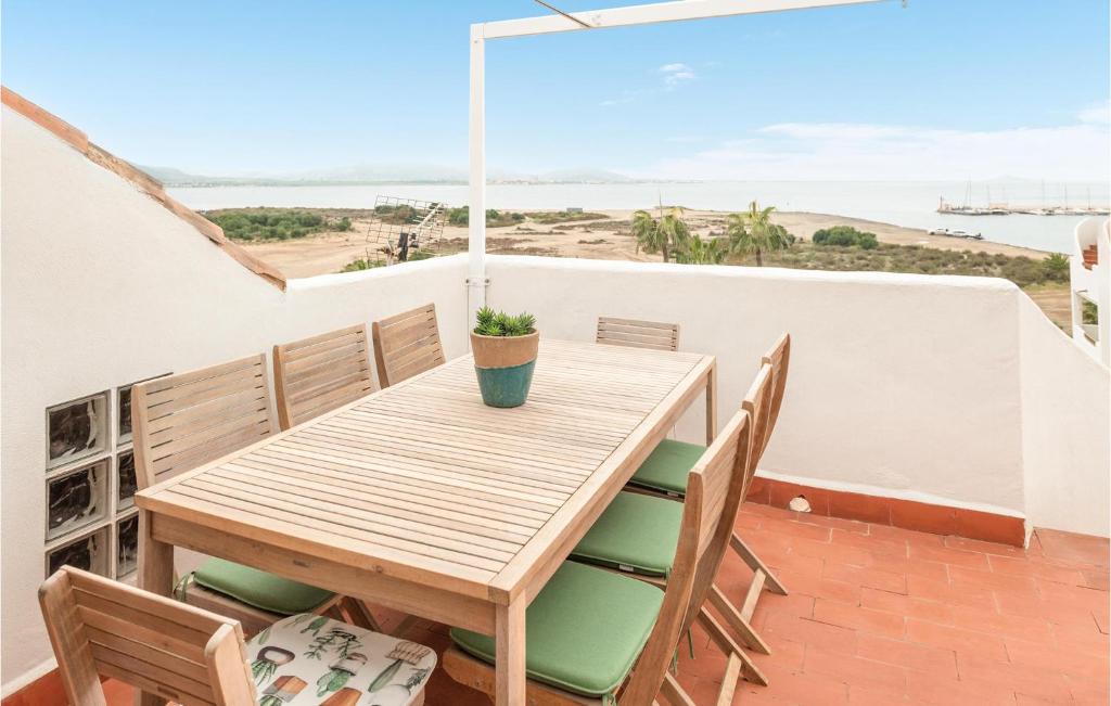 - une table et des chaises en bois sur un balcon donnant sur la plage dans l'établissement Stunning Apartment In La Manga With Kitchenette, à La Manga del Mar Meno