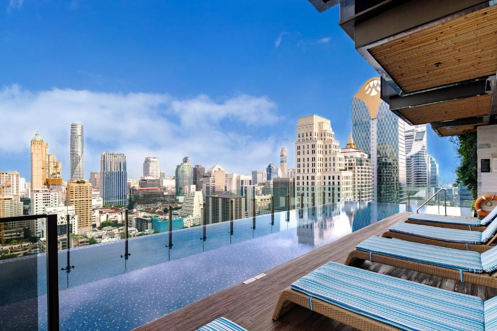 a rooftop pool with a view of the city at Hotel Indigo Bangkok Wireless Road by IHG in Bangkok