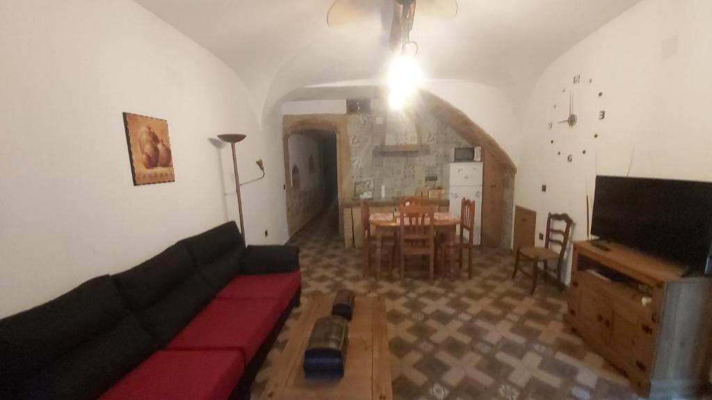 a living room with a couch and a dining room at La casina de Carmina in Arroyomolinos de Montánchez