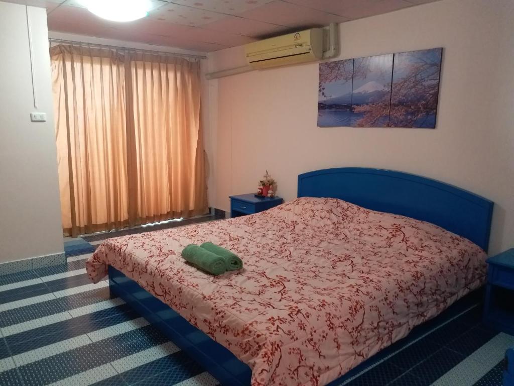 sypialnia z niebieskim łóżkiem z czerwoną kołdrą w obiekcie Merit Mansion w mieście Bangkok