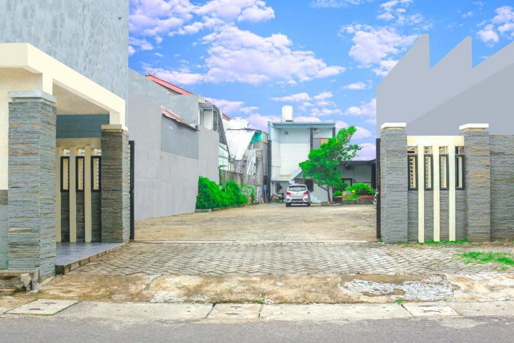 um edifício com um parque de estacionamento em frente em HP Residence Mitra RedDoorz near Alun Alun Kediri em Kediri