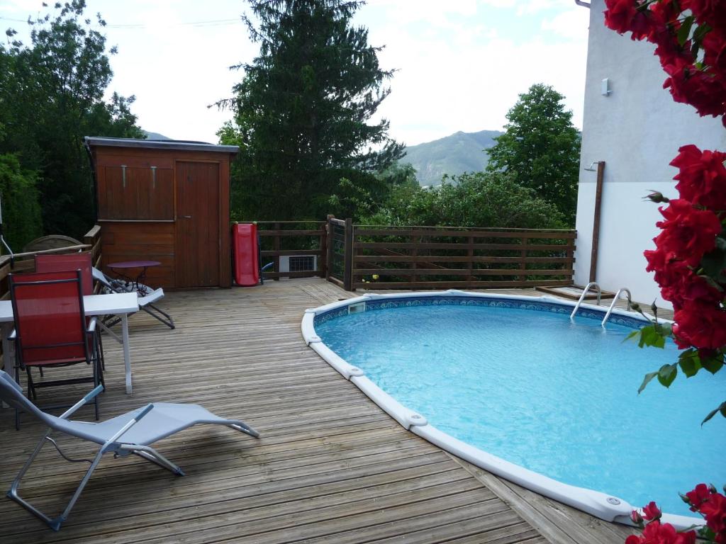 een zwembad op een terras met stoelen en een tafel bij Le Tamaris in Die