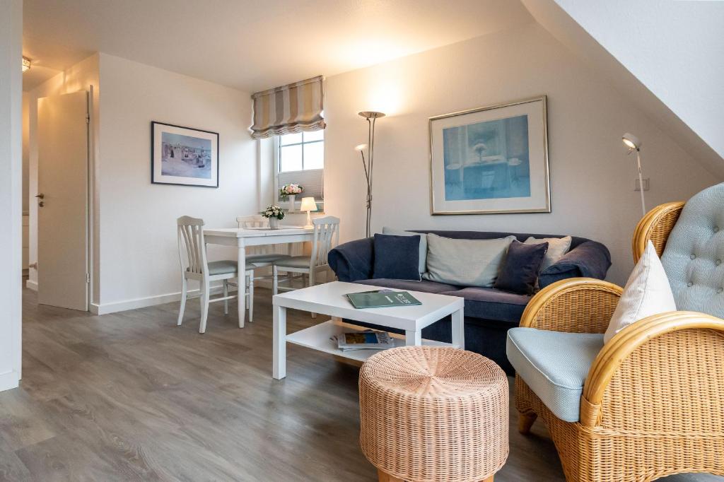 a living room with a couch and a table at Haus Dünenrand, App 2 in Wenningstedt