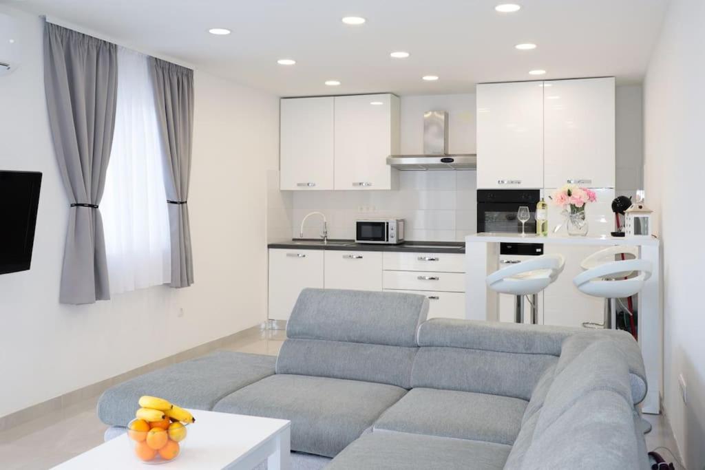 a living room with a couch and a kitchen at Apartments Ane 1 Tisno in Tisno