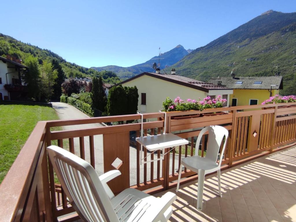 een terras met witte stoelen en uitzicht op de bergen bij Appartamento Wilma in Spormaggiore
