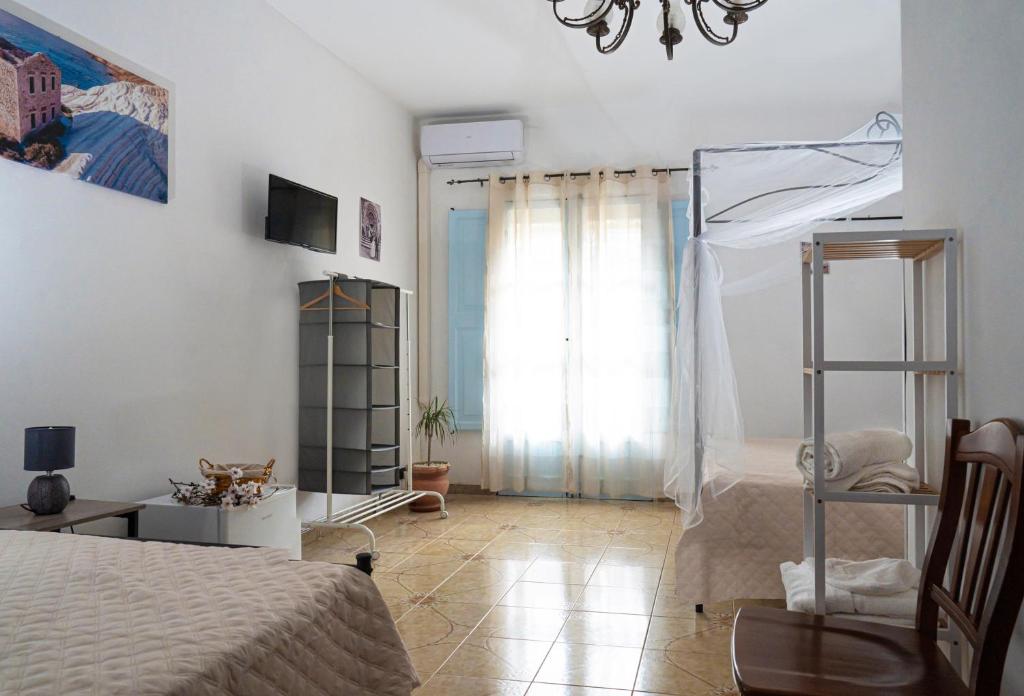 um quarto branco com uma cama e uma janela em B & B Agrigento antica em Agrigento