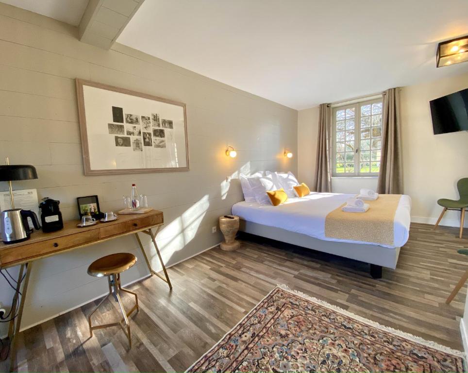 a hotel room with a bed and a desk and a bed at Domaine Utah Beach - Le Grand Hard in Sainte-Marie-du-Mont