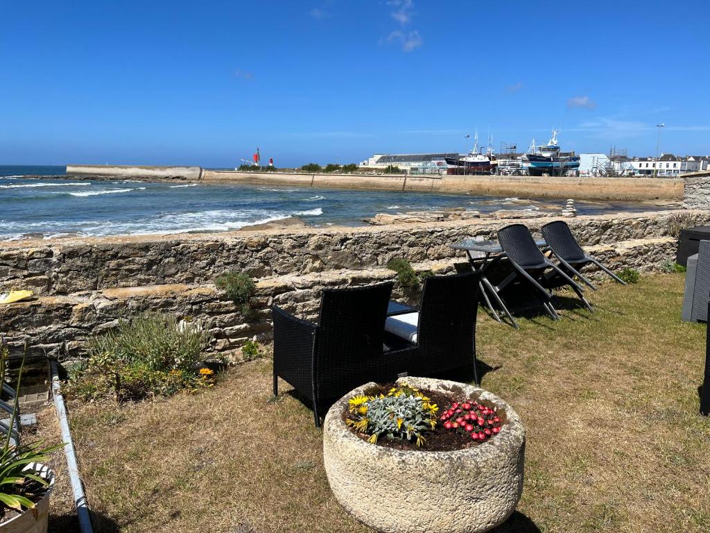 a group of chairs and flowers in a planter by the beach at La Rose des Mers in Tréffiagat