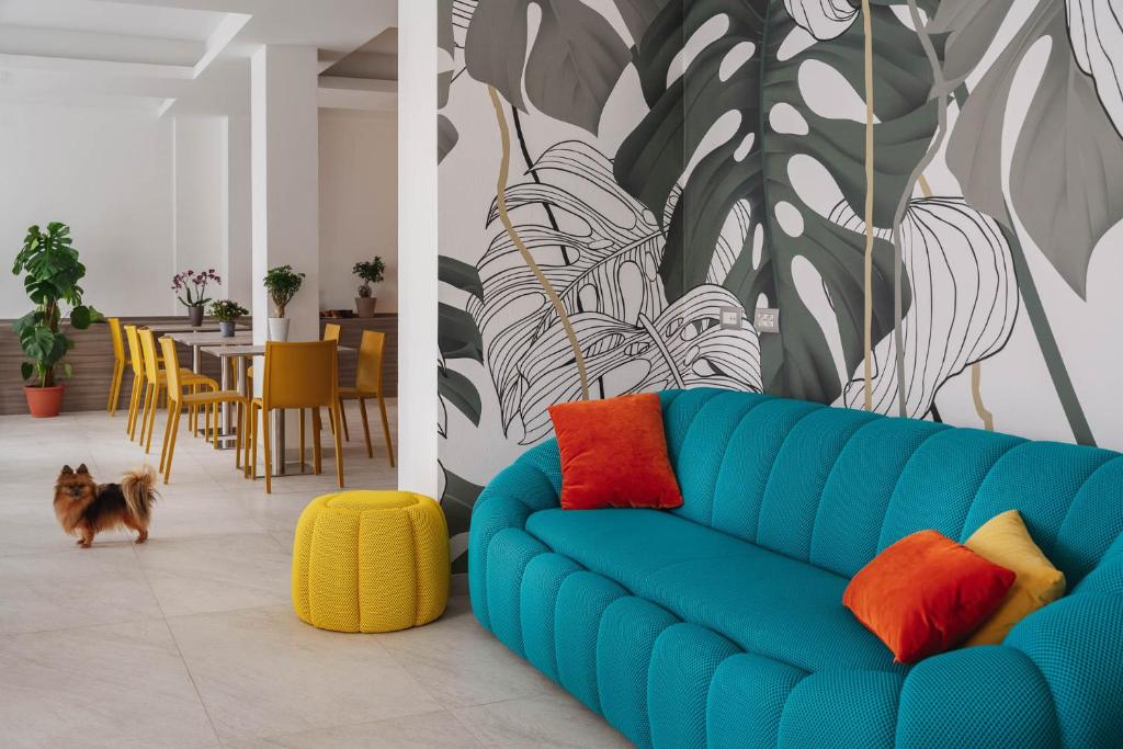 a blue couch with colorful pillows in a living room at Nido Suite & Apartments in Cesenatico