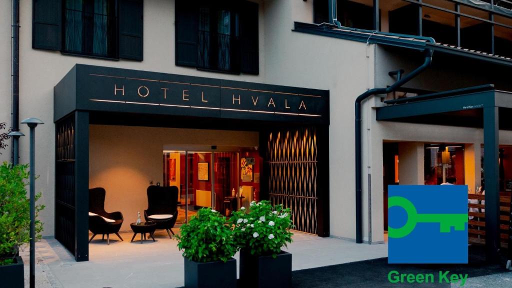 a hotel ivka with chairs and plants in front of a building at Hotel Hvala Superior - Topli Val in Kobarid
