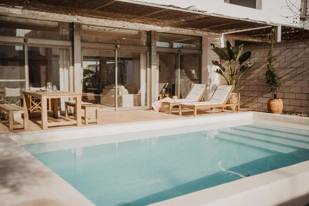 a swimming pool with chairs and a table next to a house at Casa2patis in El Poblenou del Delta