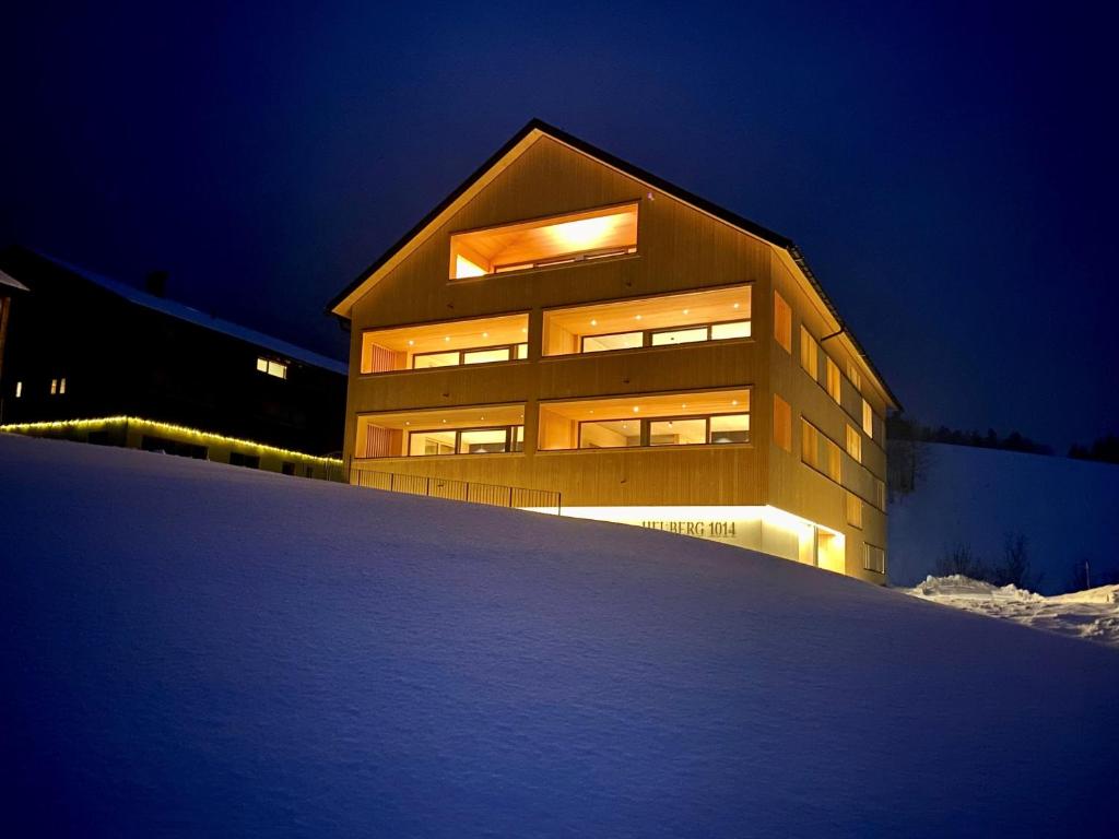 un gran edificio en la nieve por la noche en HEUBERG 1014 - FERIEN - Wohnen en Schwarzenberg im Bregenzerwald