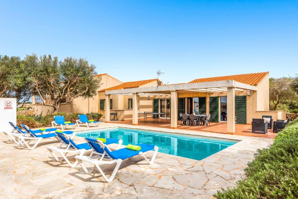 uma piscina com cadeiras e uma casa em Villa Flomertor 2 em Cala en Blanes