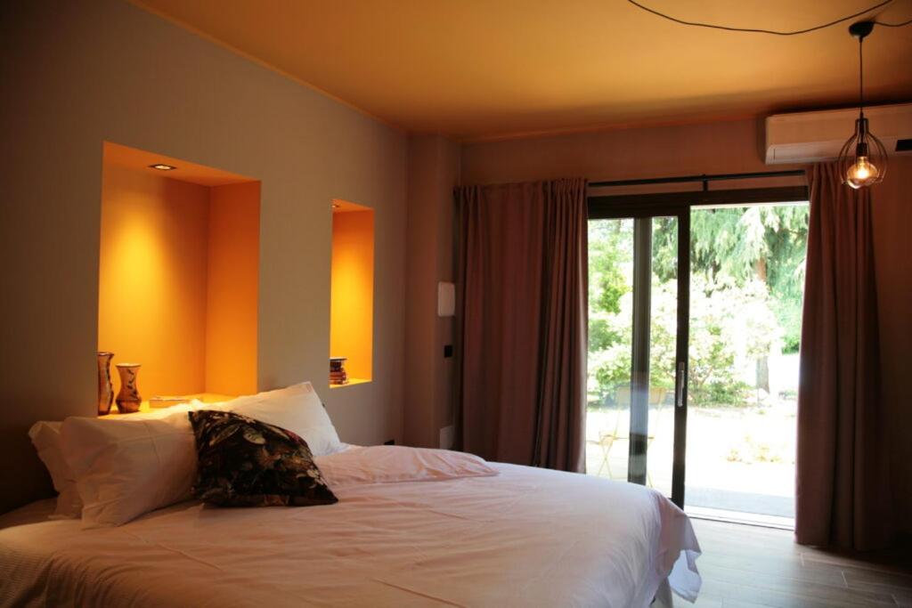 a bedroom with a bed and a large window at Il Giardino Segreto in Fogliano Redipúglia