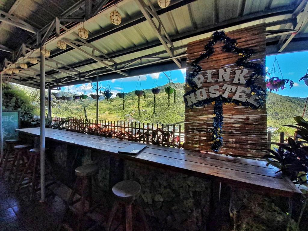 um bar com vista para uma montanha através de uma janela em Banaue Pink Eco hostel em Banaue