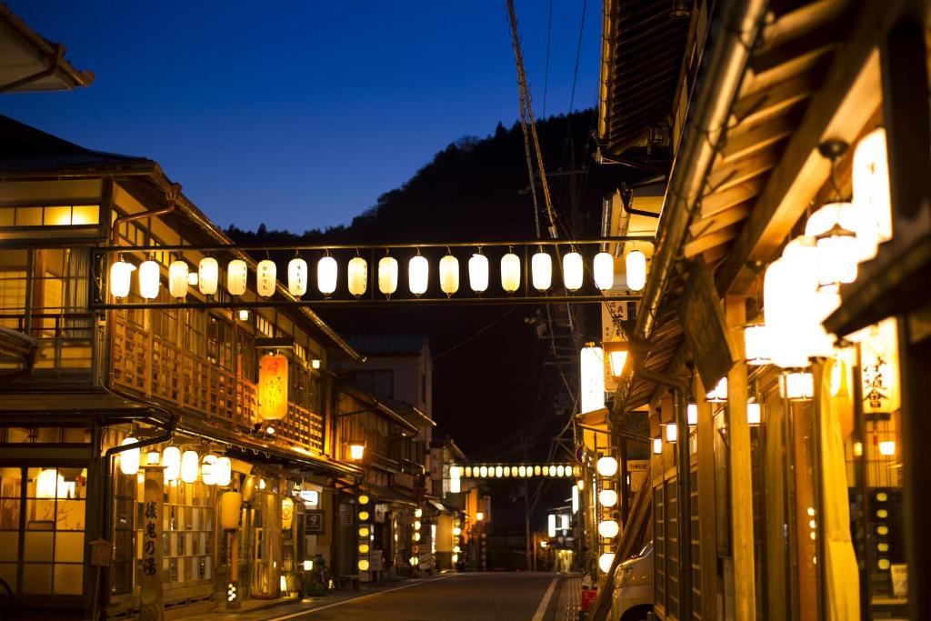 une rue la nuit avec des lumières sur les bâtiments dans l'établissement Hanaya Tokubei, à Tenkawa