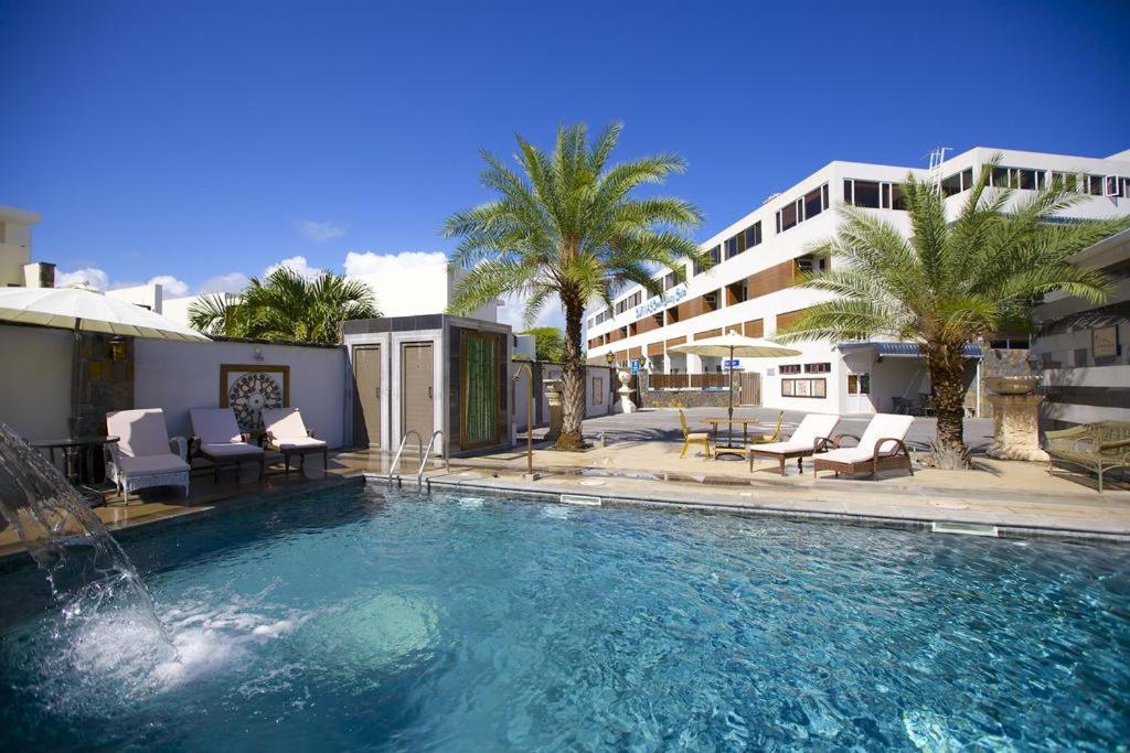 ein großer Pool mit Stühlen und ein Gebäude in der Unterkunft Burnas Beach in Pereybere