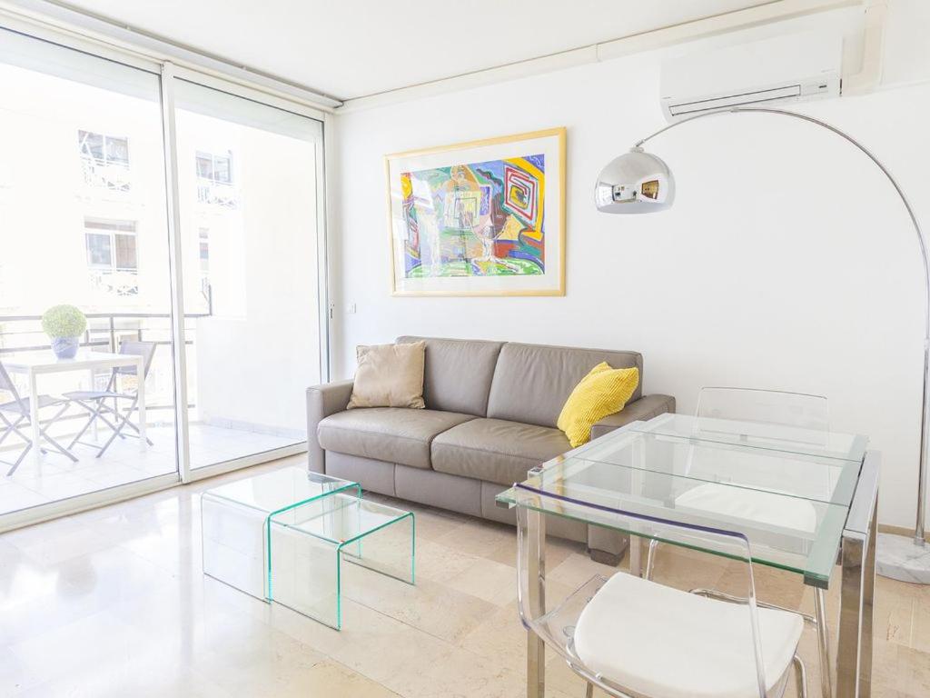 ein Wohnzimmer mit einem Sofa und einem Glastisch in der Unterkunft Lovely One bedroom Colony in Cannes