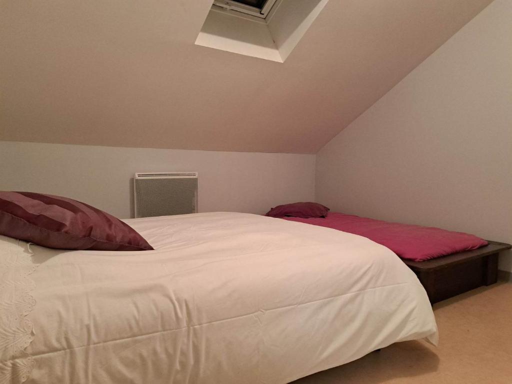 een slaapkamer met een groot wit bed met rode kussens bij Chambre privative dans un grand appartement in Langres