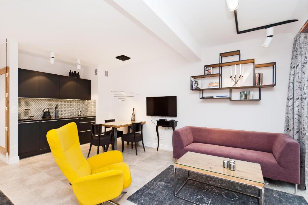een woonkamer met een bank, stoelen en een tafel bij Apartamenty Sun & Snow Kazimierz Luxory in Krakau