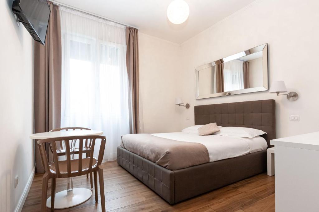 Schlafzimmer mit einem Bett, einem Tisch und einem Spiegel in der Unterkunft La finestra sul canale in Bologna