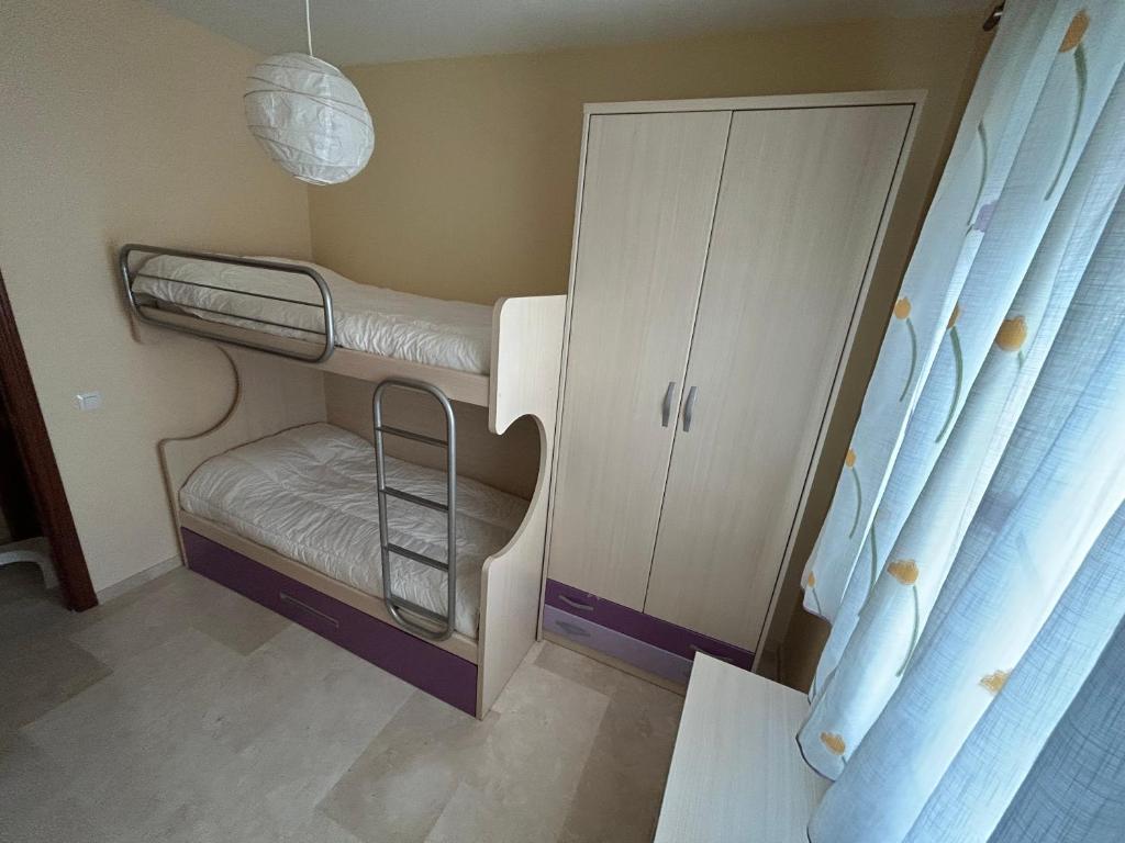 a small room with a bunk bed and a cabinet at Casa Tia Angelita in Aguilar de la Frontera