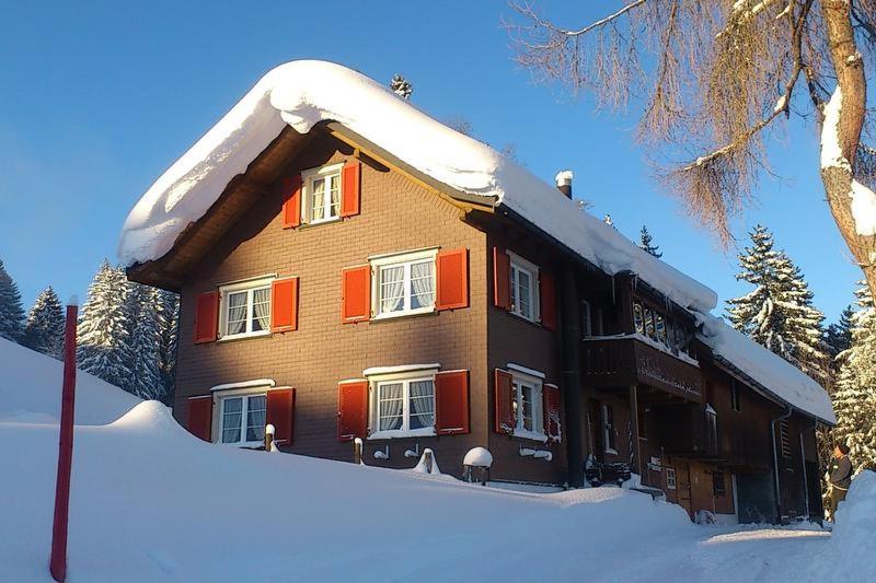 a large house with snow on the front of it at Bauernhaus Cafrida in Flumserberg
