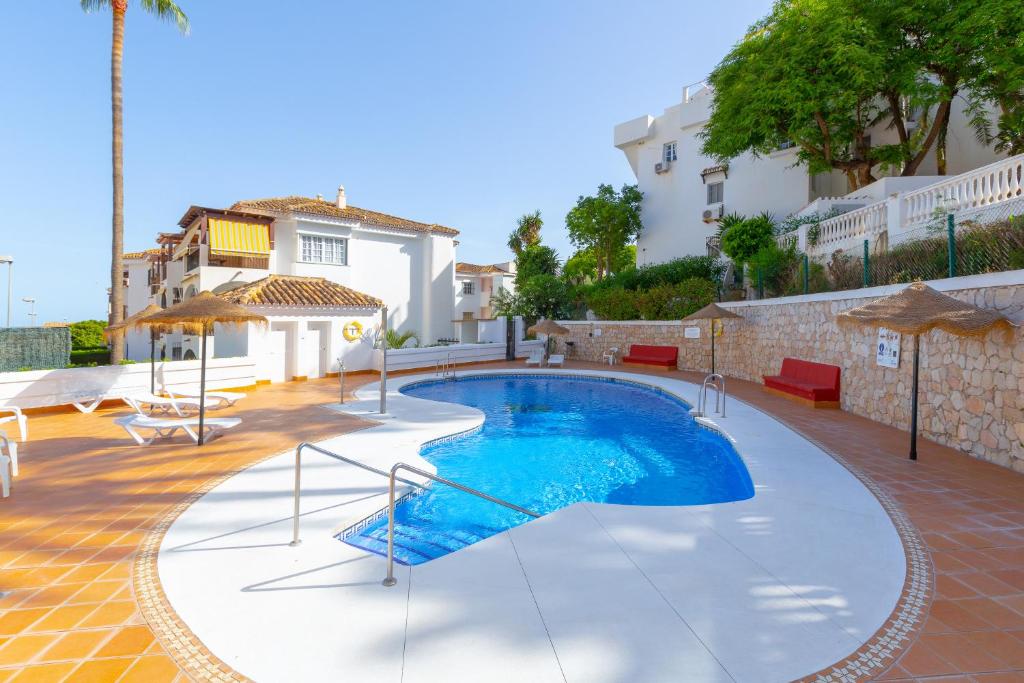 - une piscine au milieu d'une cour avec une maison dans l'établissement Lovely seaview apartment, à Benalmádena