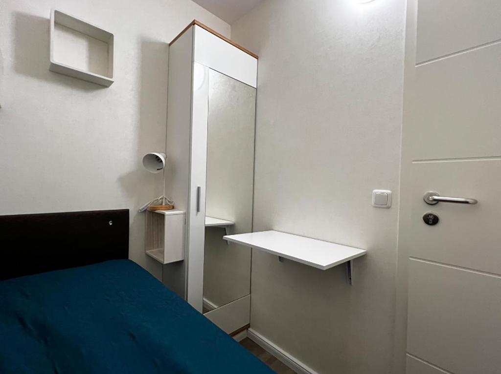 een kleine kamer met een bed en een spiegel bij MG-Quartier Hostel in Mönchengladbach