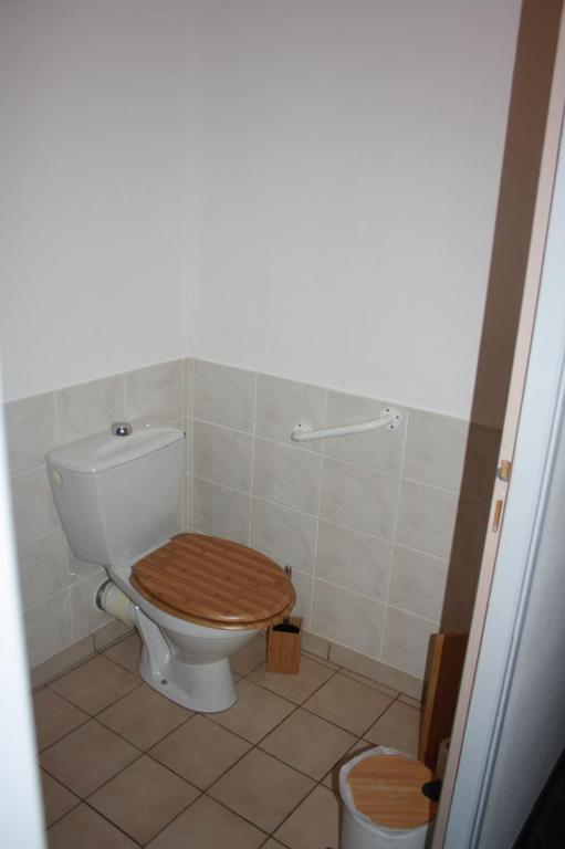 a bathroom with a toilet with a wooden toilet seat at Gite De LA BALLADE in François