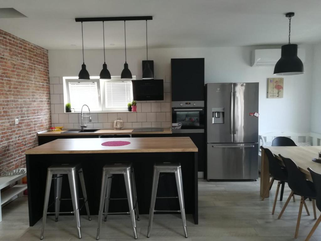 a kitchen with a kitchen island with bar stools at Apartmani Radić Rg in Rogoznica