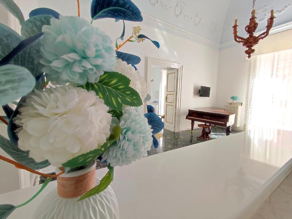 un vase avec des fleurs bleues et blanches dans une pièce dans l'établissement Dimora della Marchesa - al Duomo, à Manfredonia