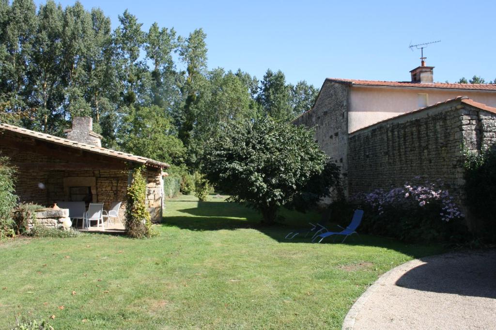 a yard with a building and a chair in it at Gite De LA BALLADE in François