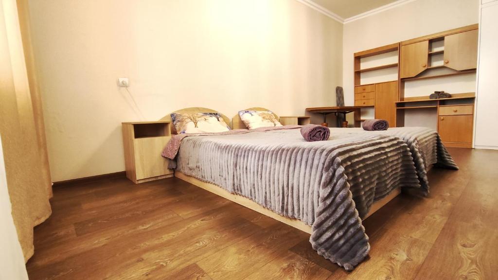 a bedroom with a bed and a wooden floor at Водопійна 19 CityRooms in Bila Tserkva