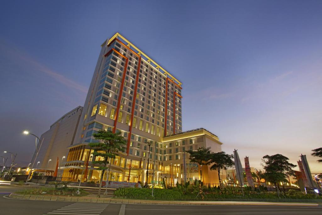 a tall building with lights on in a city at HARRIS Hotel & Conventions Bekasi in Bekasi